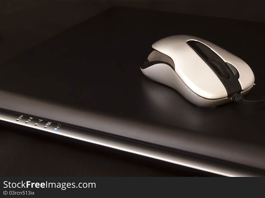 Black laptop and silver mouse. Black laptop and silver mouse