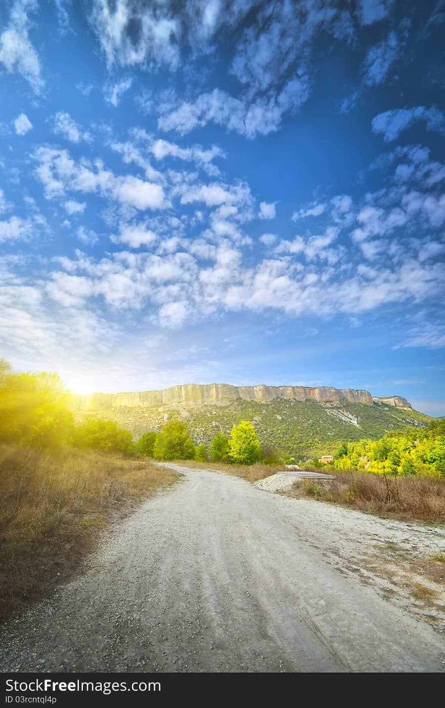 Road runs along the mountain at sunrise