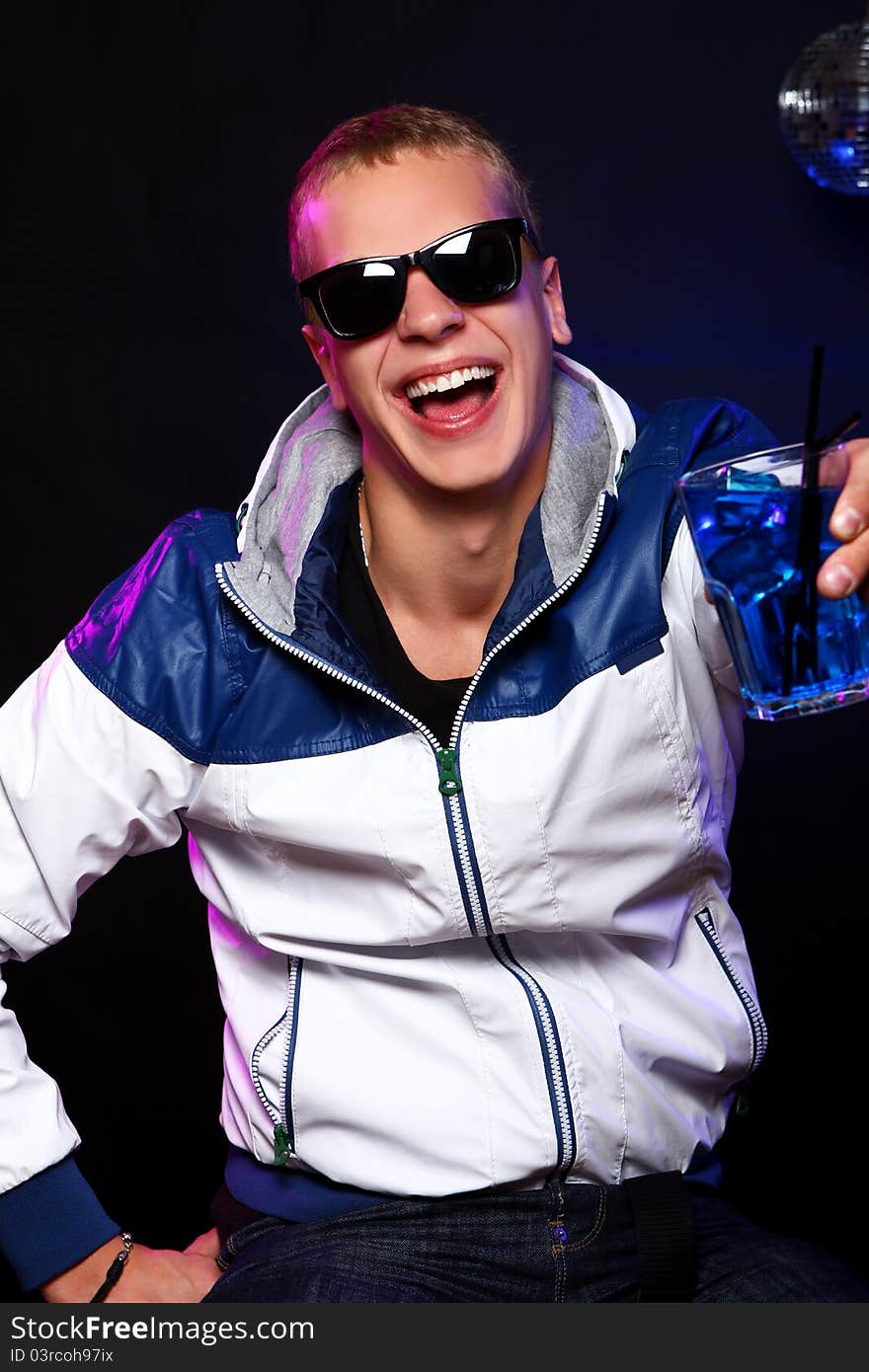 Young stylish guy with a blue cocktail in the nightclub. Young stylish guy with a blue cocktail in the nightclub