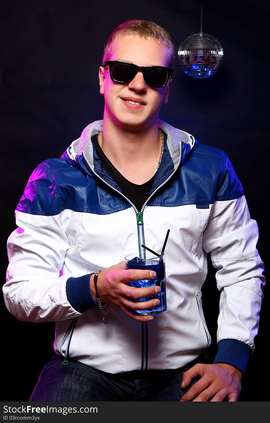 Young stylish guy with a blue cocktail in the nightclub. Young stylish guy with a blue cocktail in the nightclub