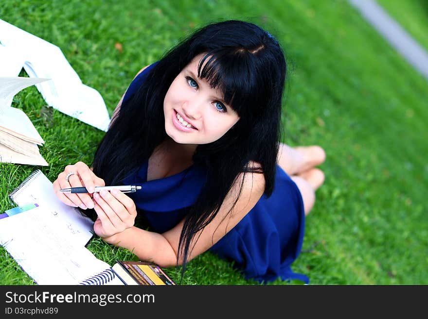 Beautiful student girl studying in green park. Beautiful student girl studying in green park