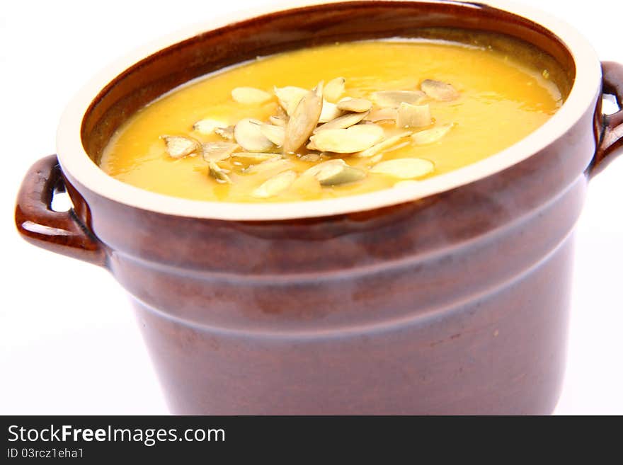 Bowl of pumpkin soup on white background