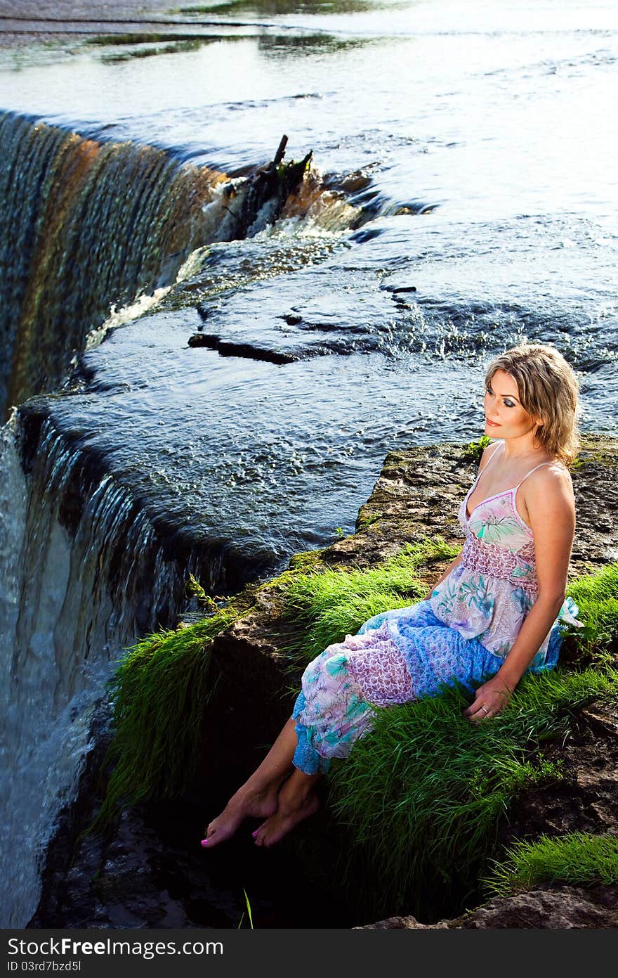 Portrait of beautiful girl enjoying beauty of nature on brink of precipice of river waterfalls in early summer morning. Portrait of beautiful girl enjoying beauty of nature on brink of precipice of river waterfalls in early summer morning