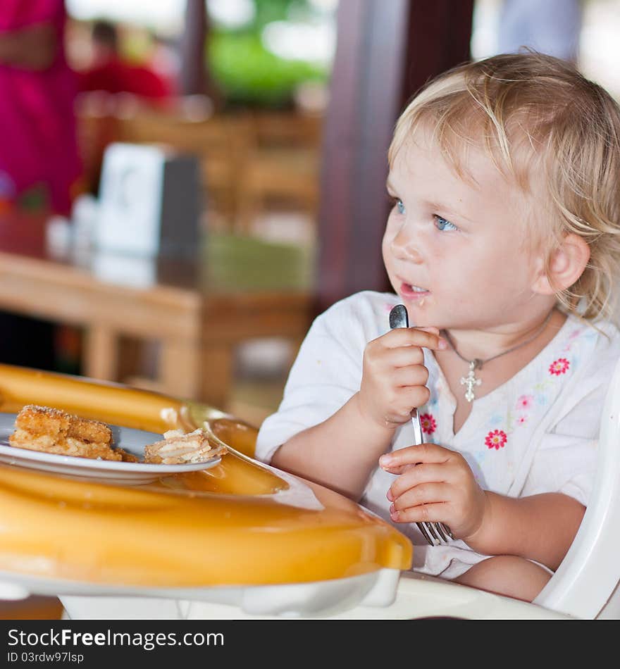 Adorable Baby Eating Cake In A Chair