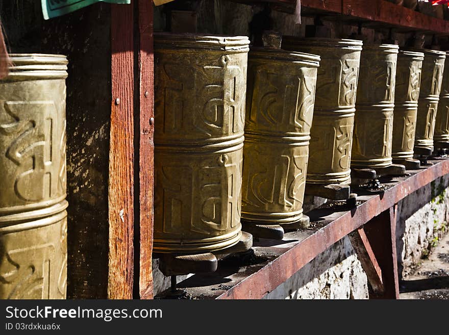 Tibetan prayer wheels at the gate of a monastery in tibet.