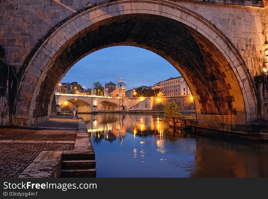 Bridge crossing the river Tiber and Cathedral in twilight. Bridge crossing the river Tiber and Cathedral in twilight