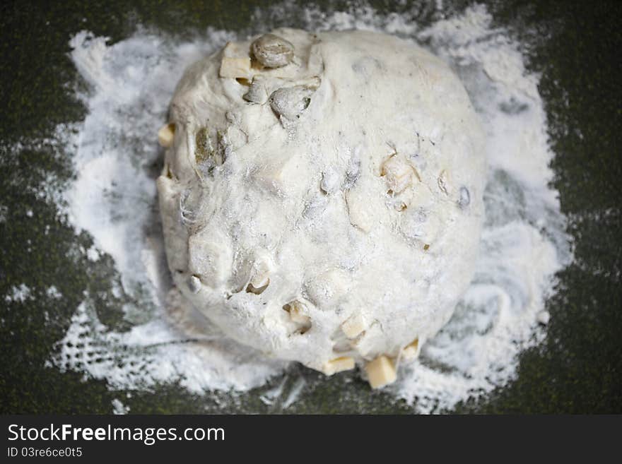 Artichoke cheese bread dough on a cutting board with flour