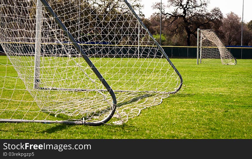 Two soccer goals on green grassy field