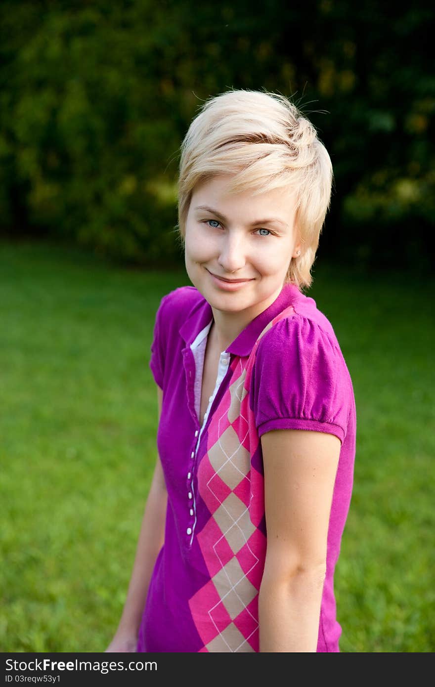 Closeup portrait of young smiling woman outdoors in the park