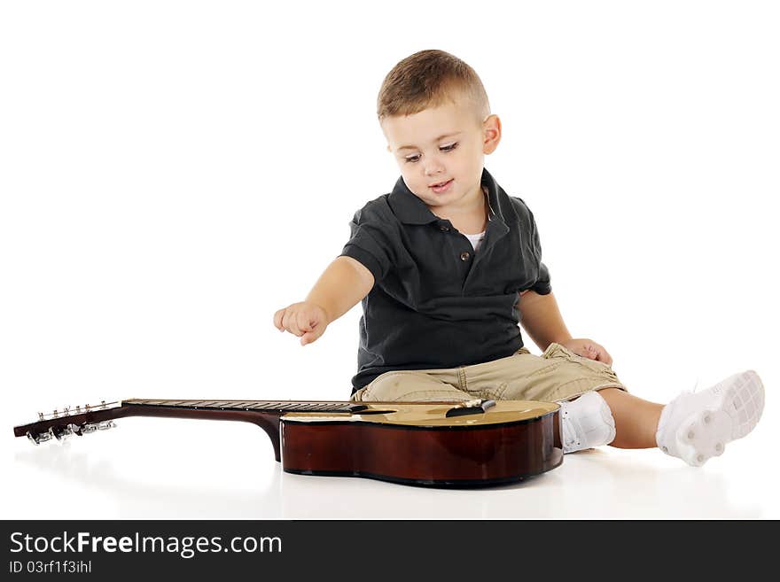 An adorable toddler happily plucking the strings of a small guitar. Isolated on white. An adorable toddler happily plucking the strings of a small guitar. Isolated on white.