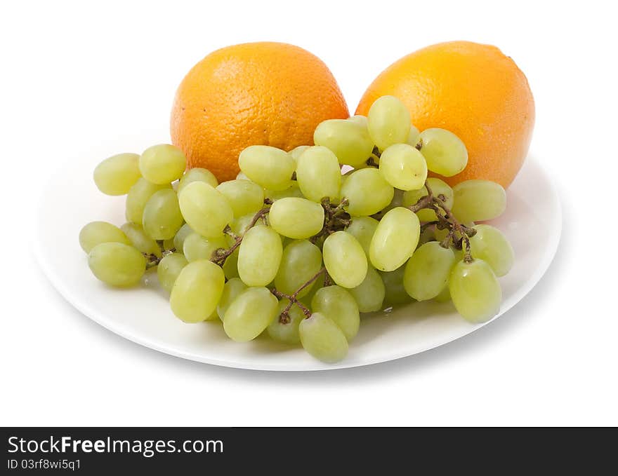 Bunch of grapes and orange on a plate