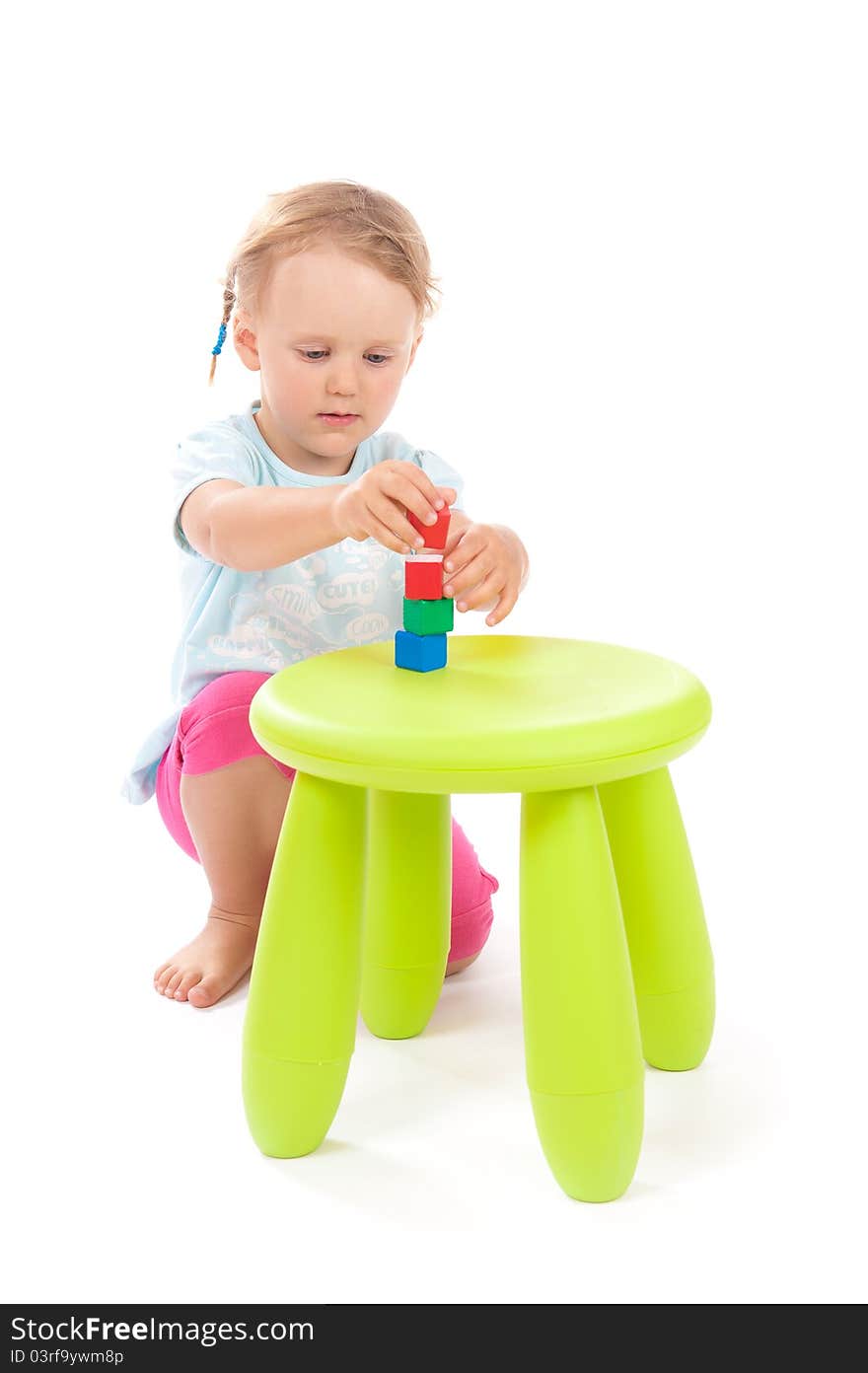 Little girl playing with blocks on the stool