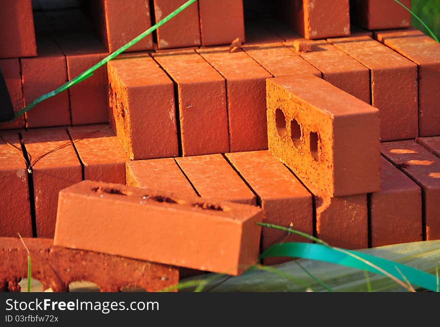 Stack of three hole red bricks.