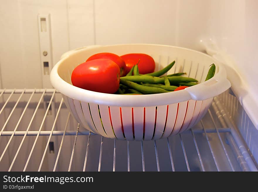 Fresh tomatoes and green beans in refrigerator