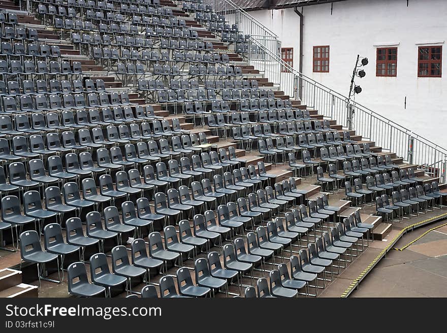 Plenty of grey seats arranged on temporary hall. Plenty of grey seats arranged on temporary hall