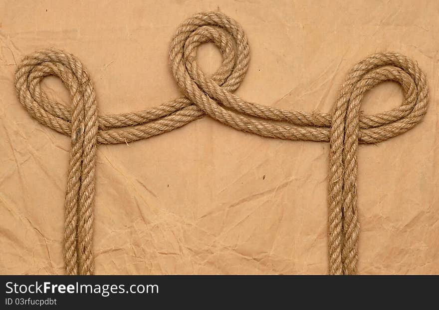 Aged rope on the old paper background. Aged rope on the old paper background