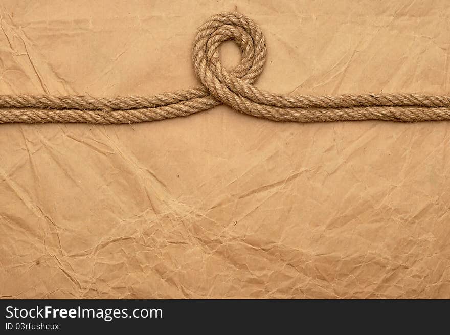 Aged rope on the old paper background. Aged rope on the old paper background