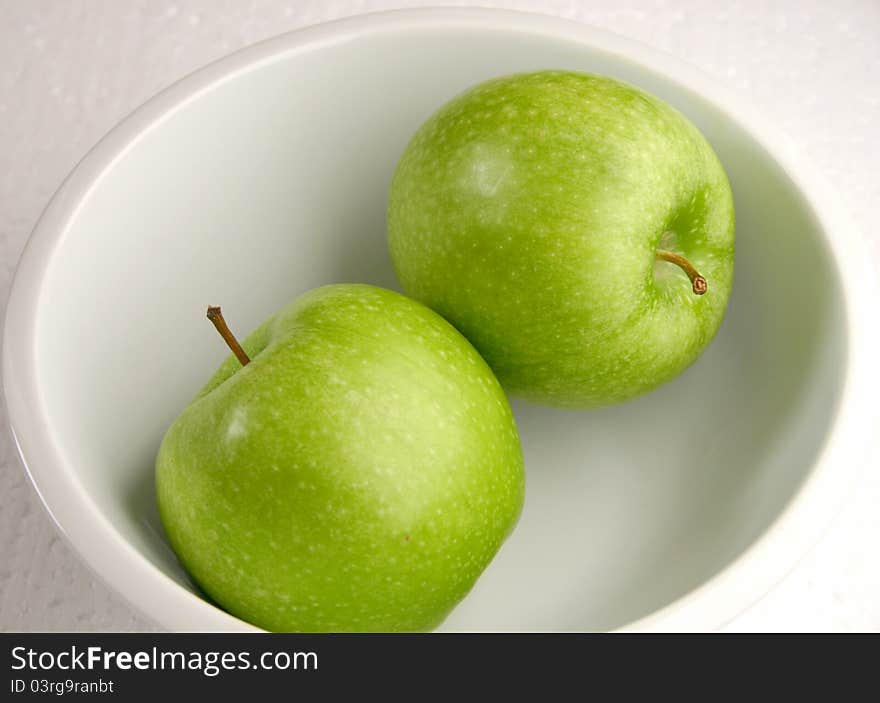 Two green colorful apples in a dish. Two green colorful apples in a dish