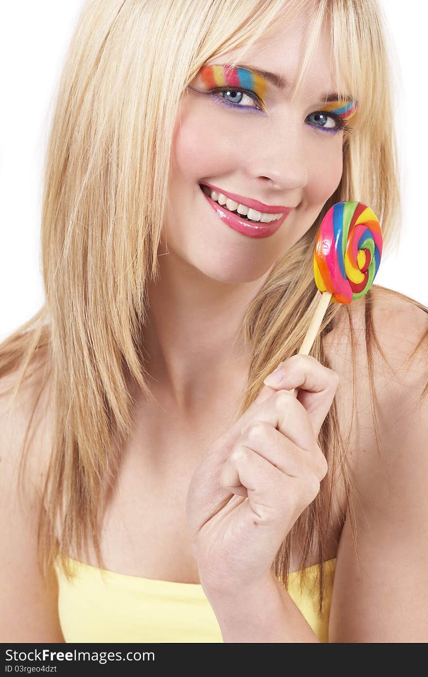 Beautiful blonde woman with colorful eye make-up holding a lollipop