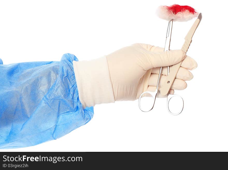 Scalpel and clamp with swab in the hand of the surgeon during a surgery. Scalpel and clamp with swab in the hand of the surgeon during a surgery