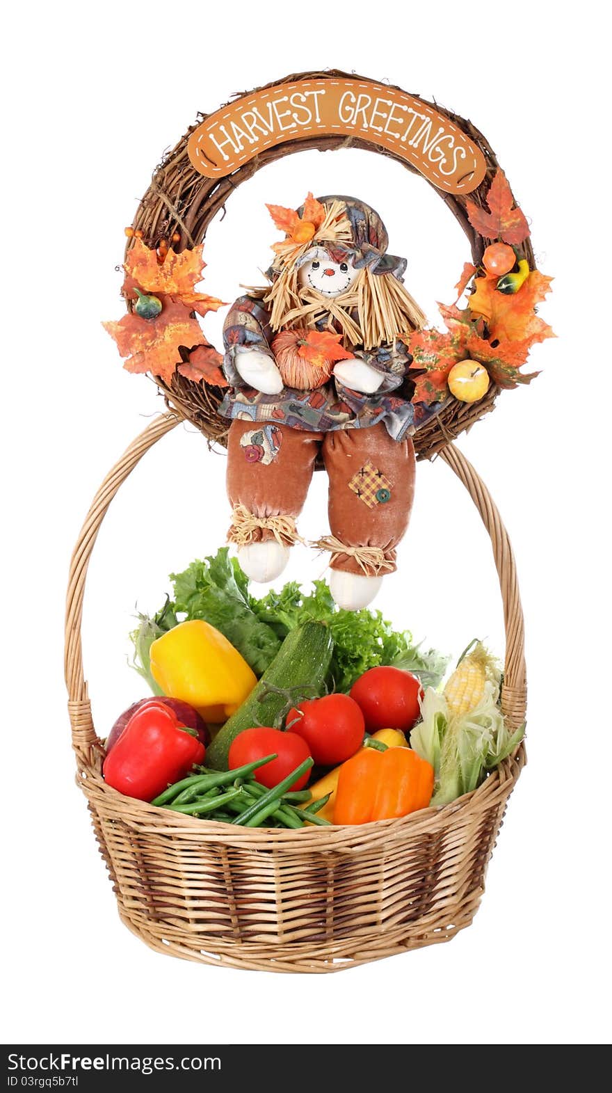 Harvest wreath sitting on top of a basket of vegetables isolated on white. Harvest wreath sitting on top of a basket of vegetables isolated on white