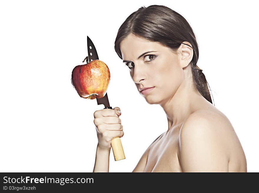 Dangerous looking woman, is holding a big kitchen knife with a apple stuck on it. She is naked, has her hair in a ponytail and poses on a white background. Dangerous looking woman, is holding a big kitchen knife with a apple stuck on it. She is naked, has her hair in a ponytail and poses on a white background.