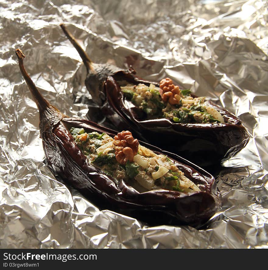 Baked aubergines stuffed with walnut filling on foil