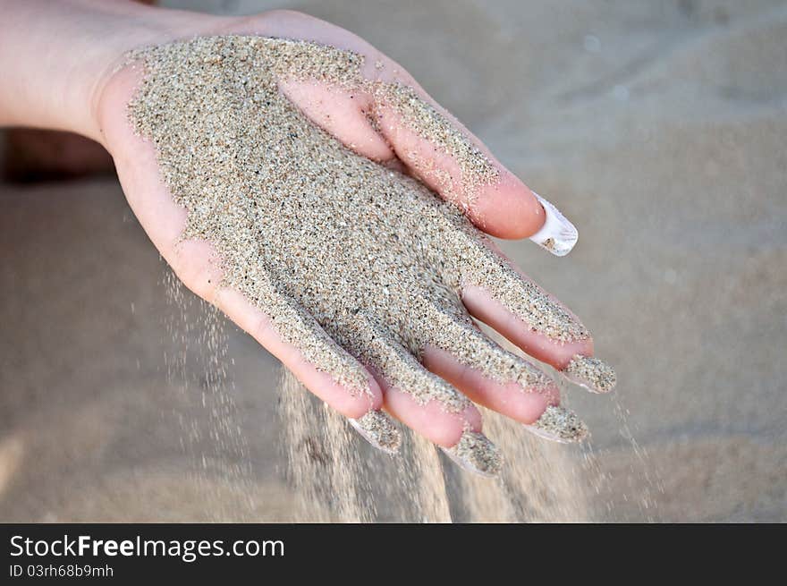 Sand pours hand