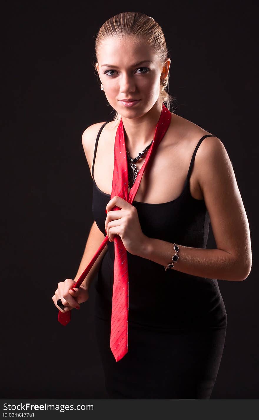 Young girl in a black dress with red tie. Young girl in a black dress with red tie