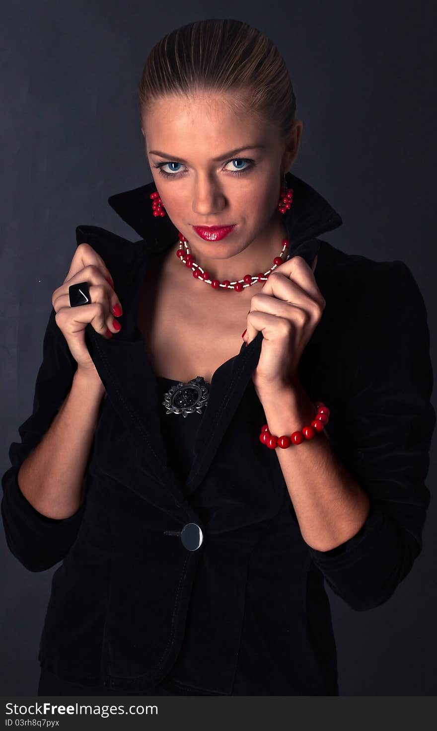 Girl with a stern look, dressed in black with red accessories in the form of a vampire. Girl with a stern look, dressed in black with red accessories in the form of a vampire