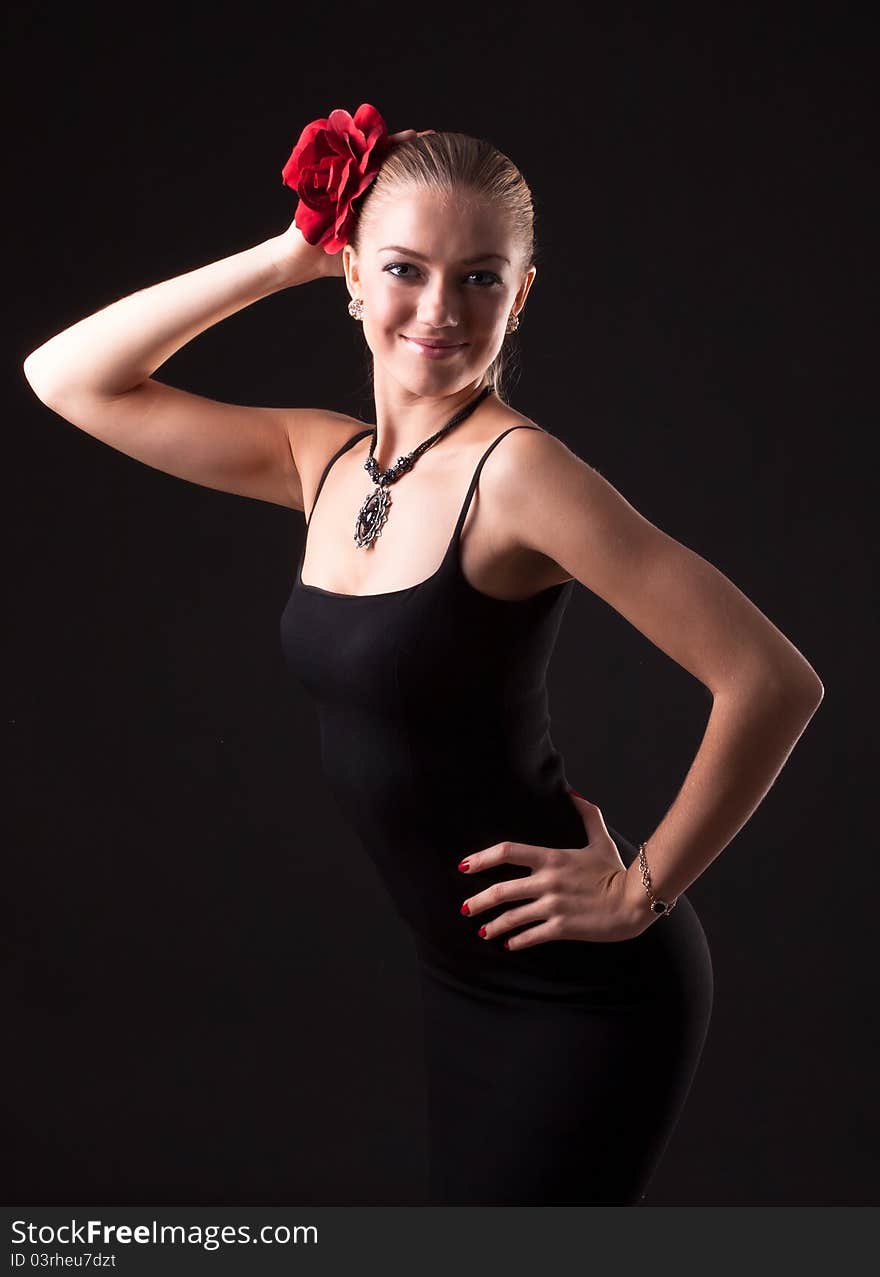 Smiling young girl in black dress with red rose