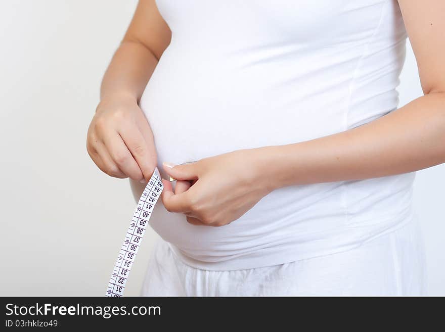 Pregnant woman touching her belly with hands