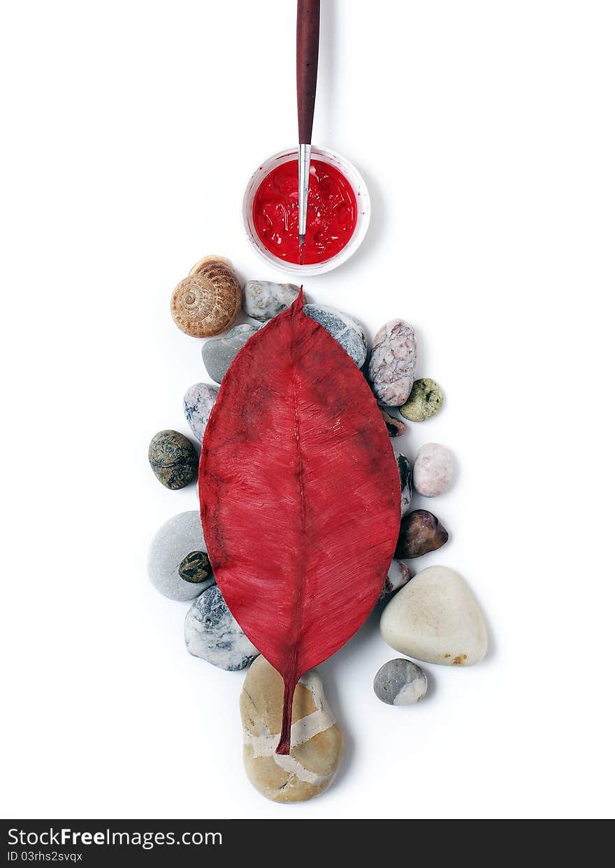 Stones, red leaf and brush on a white