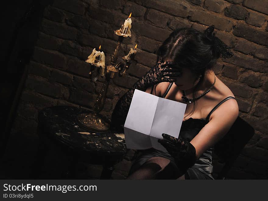 A girl reading by the light of candle. A girl reading by the light of candle