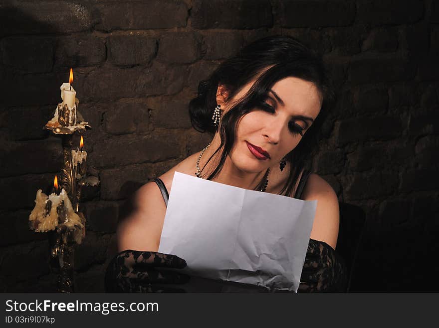 A girl reading by the light of candle. A girl reading by the light of candle