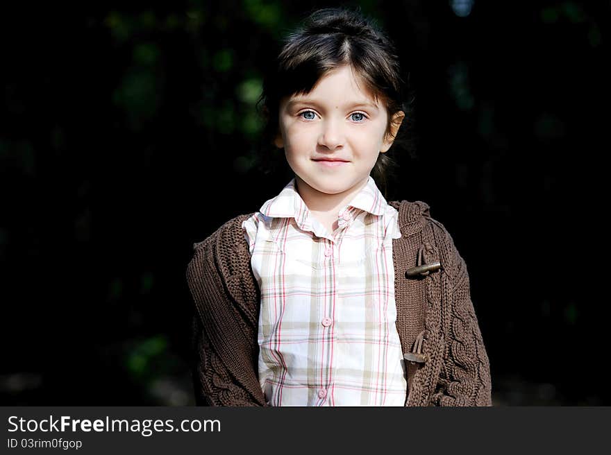 Portrait of adorable child girl in autumn forest