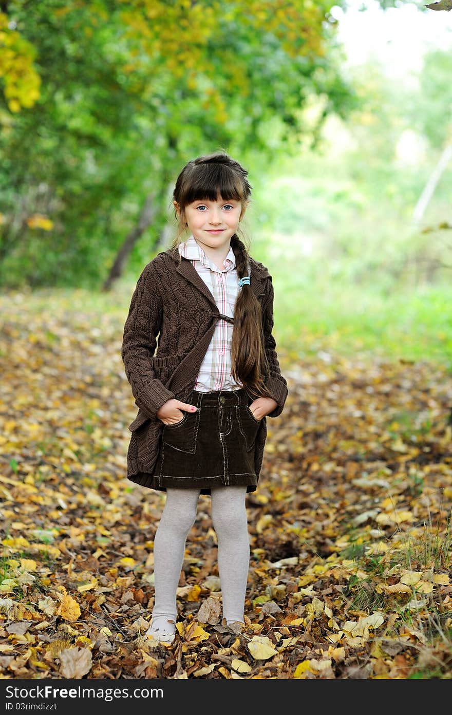 Portrait of adorable child girl in autumn forest