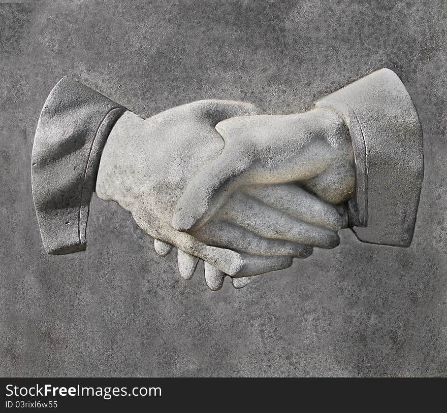 Stone carving of two hands in a handshake. Stone carving of two hands in a handshake.