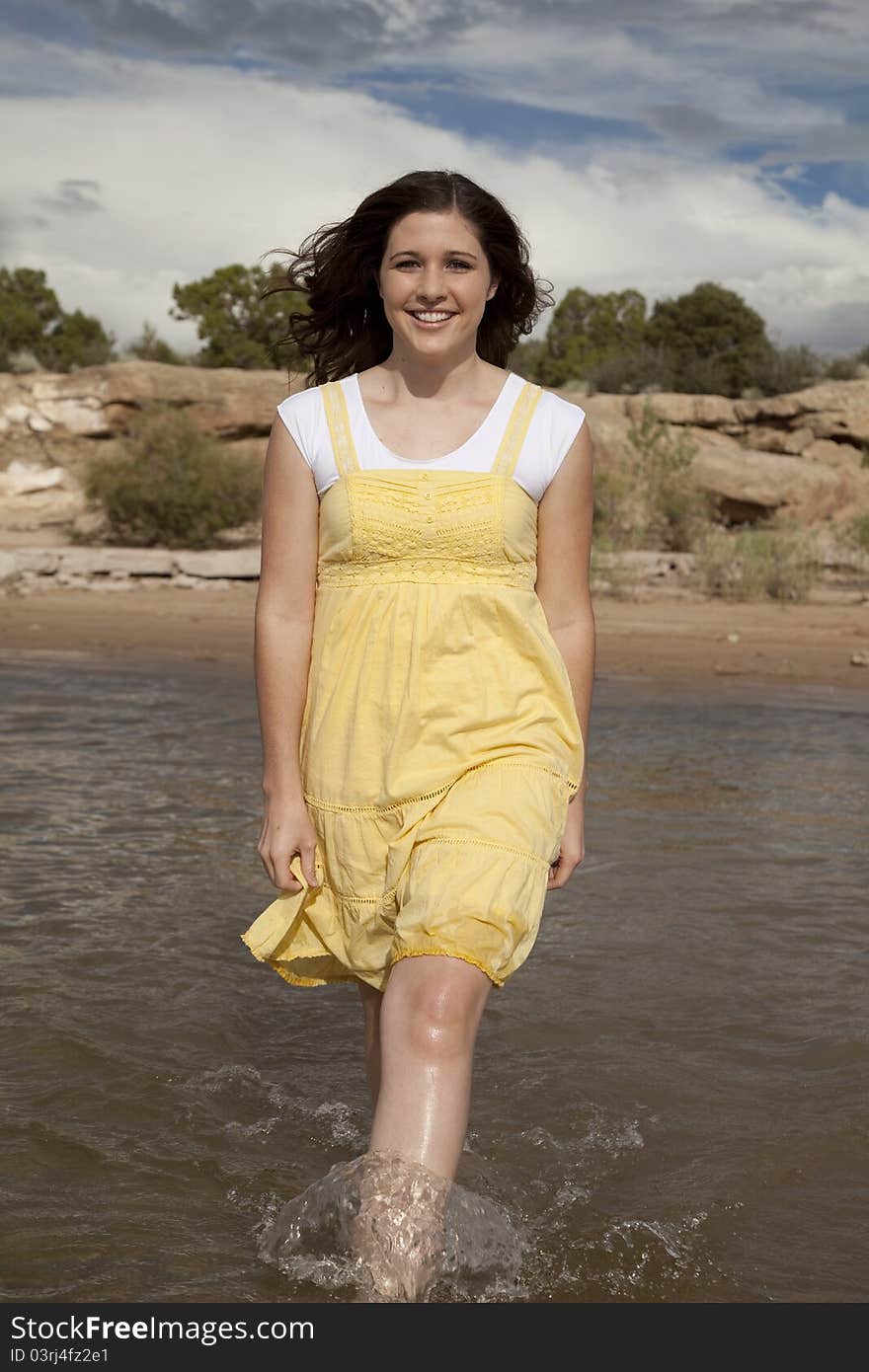 A woman walking in the water with a big smile on her face. A woman walking in the water with a big smile on her face.