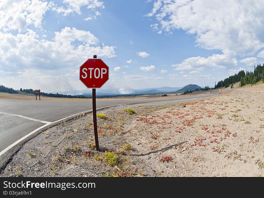 Stop sign in the foreground and forest fire in the distance. Stop sign in the foreground and forest fire in the distance.