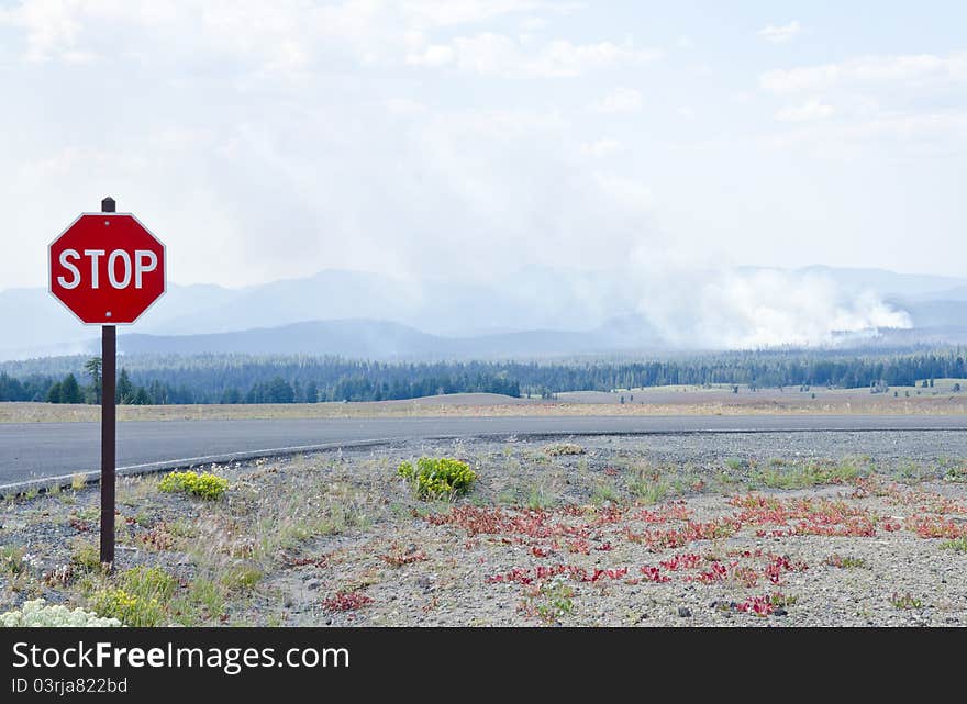 Stop sign in the foreground and forest fire in the distance. Stop sign in the foreground and forest fire in the distance.