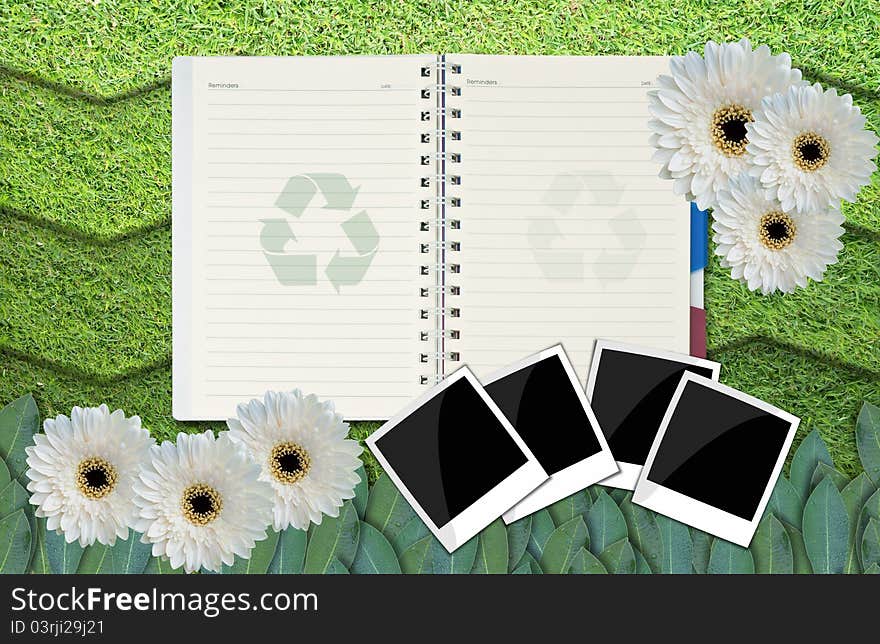 Opened blank notepad on grass background.