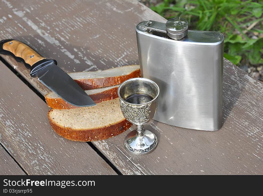 Bread steel flask and knife on the table. Bread steel flask and knife on the table