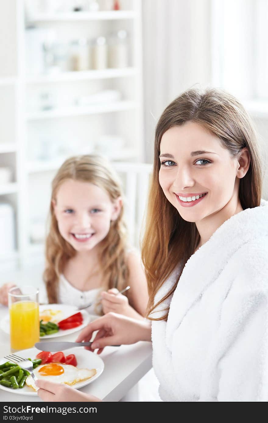 A mother and child have breakfast in the kitchen. A mother and child have breakfast in the kitchen