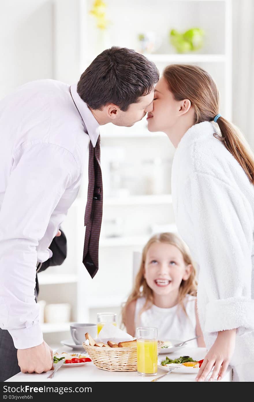 A couple kisses in front of the child