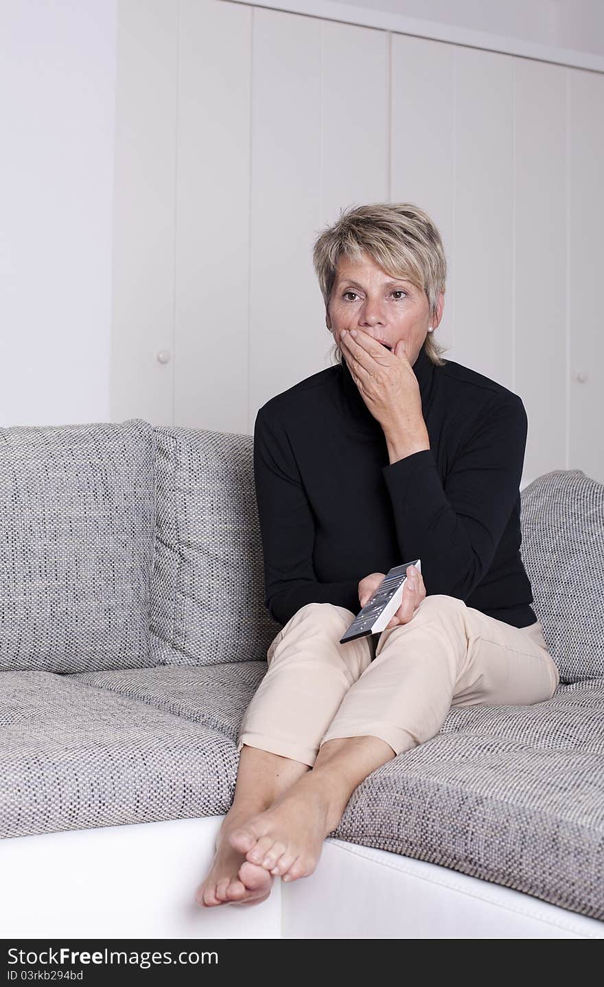 Senioring yawns with remote in hand. Senioring yawns with remote in hand