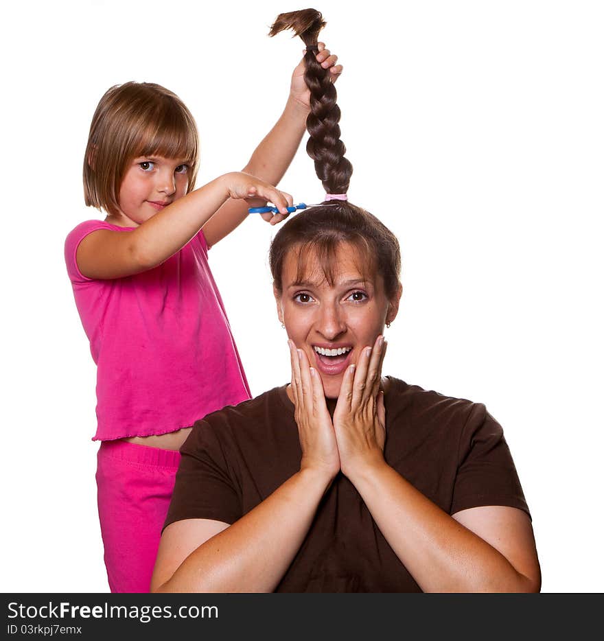 Little girl with a devilish grin about to cut moms pony tail off. Little girl with a devilish grin about to cut moms pony tail off.