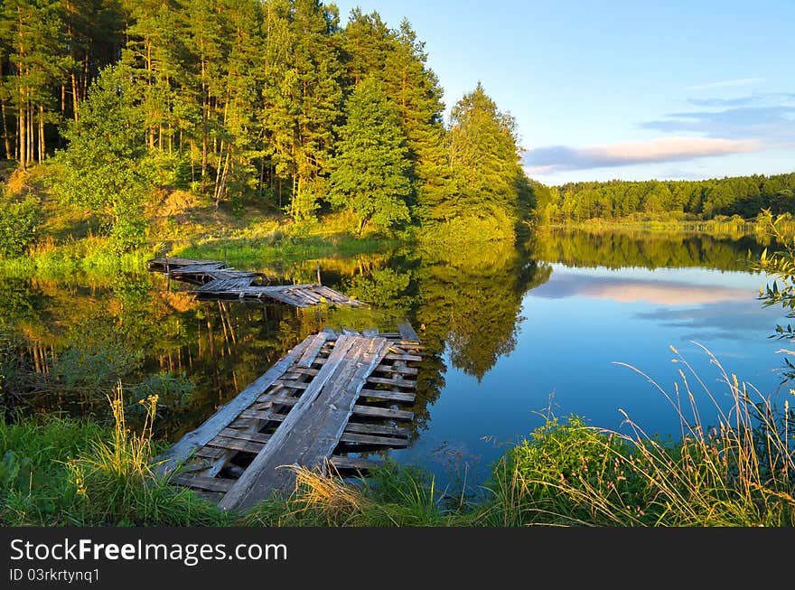 Colorful landscape with a wooden bridge over the river. Colorful landscape with a wooden bridge over the river