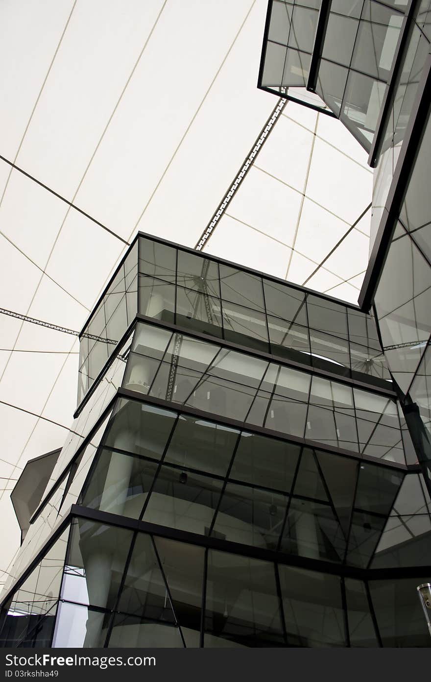 Futuristic Angular green glass building structure with white canvas canopy