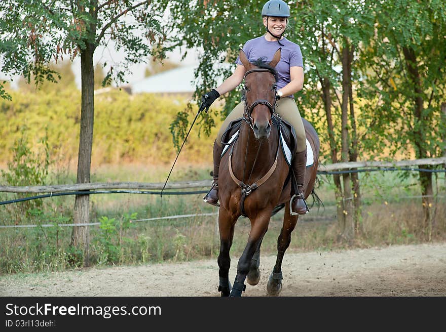 Happy young woman riding horse